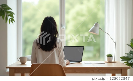 Person working at minimalist home office desk, back view 128052847