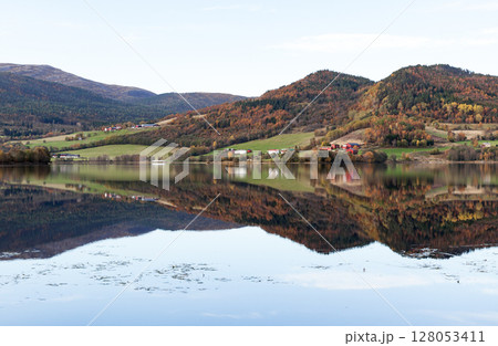 Peaceful autumn Norwegian landscape featuring a calm lake Peaceful autumn Norwegian landscape featuring a calm lake 128053411