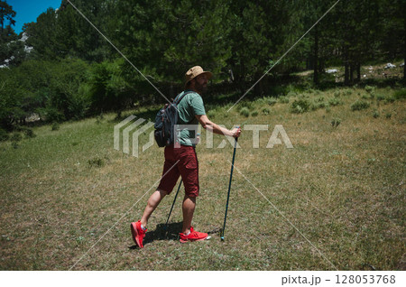 Man Hiking in a Scenic Mountain Forest Landscape on a Daytime Adventure 128053768