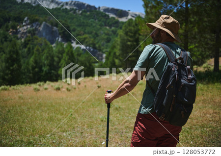 Man Hiking in the Mountains, Exploring Nature with Backpack and Hat 128053772