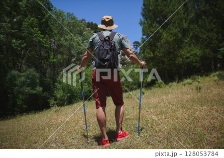 Hiker Exploring Mountain Trail with Backpack During Summer Day in Nature 128053784