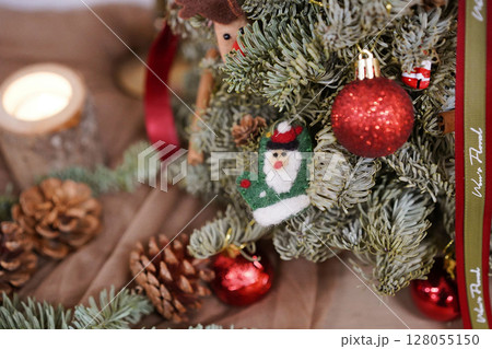 A cozy christmas scene with a beautifully decorated tree, sparkling ornaments, and natural pine cones, evoking festive warmth and holiday spirit A cozy christmas scene with a beautifully decorated tree, sparkling ornaments, and natural pine cones, evoking festive warmth and holiday spirit 128055150