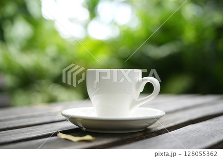 White coffee cup with lush green background 128055362