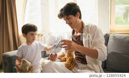 Little boy gives his dad a handmade Fathers Day card in light cozy atmosphere 128055424