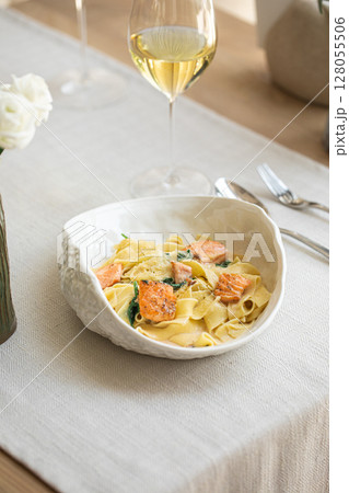 Creamy tagliatelle pasta with salmon and wine 128055506