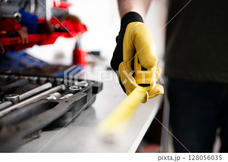 Auto Mechanic Holding Measuring Tape In Hands While In Service 128056035
