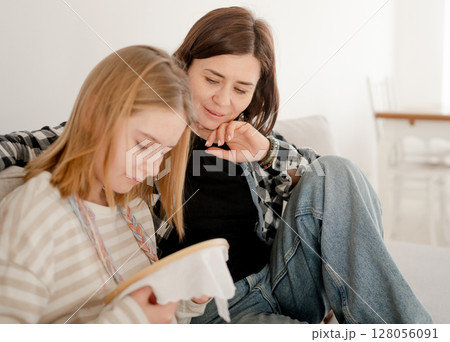 Mother Teaches Embroidery On A Hoop To Little Girl, Holding Thread With A Needle And An Embroidery Hoop Mother Teaches Embroidery On A Hoop To Little Girl, Holding Thread With A Needle And An Embroidery Hoop 128056091
