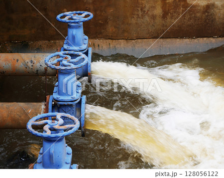 Industrial drainage system with five blue pipes discharging water into a reservoir. Concept of water management, wastewater treatment, and environmental engineering, spillway 128056122