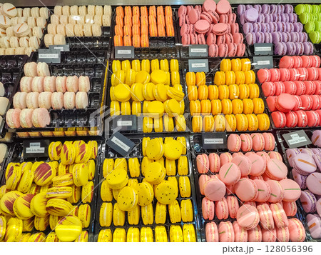 Colorful assortment of macarons displayed in trays, featuring vibrant hues of yellow, pink, orange, and purple Colorful assortment of macarons displayed in trays, featuring vibrant hues of yellow, pink, orange, and purple 128056396