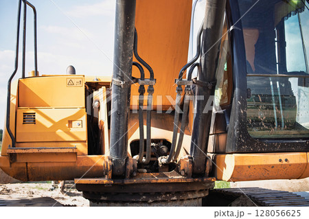 Heavy machinery in operation at a construction site during sunny daytime hours in a rural area 128056625