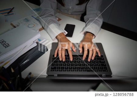 Late Night Typing. Close-up of hands typing on a laptop in an office. Late Night Typing. Close-up of hands typing on a laptop in an office. 128056788