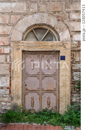 Ancient Ottoman-style arched entrance with a decorative iron door in a stone building in Kusadasi, Turkey Ancient Ottoman-style arched entrance with a decorative iron door in a stone building in Kusadasi, Turkey 128057413