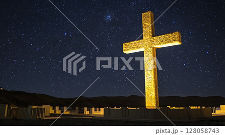 A large golden cross is lit up against a dark sky 128058743