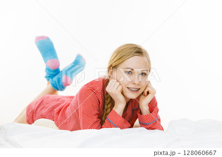 Smiling woman lying in bed Smiling woman lying in bed 128060667