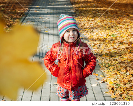 Little girl holding yellow autumn leaves, smiling outdoor park. Seasonal joy child happiness concept Little girl holding yellow autumn leaves, smiling outdoor park. Seasonal joy child happiness concept 128061350