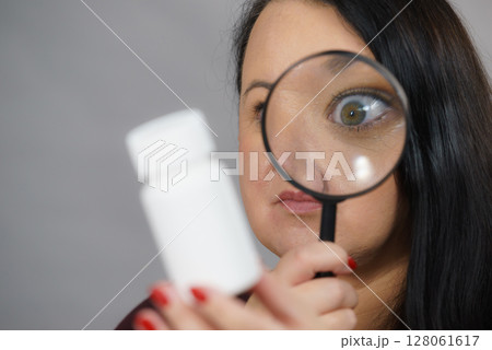 Woman investigating ingredients of medicines 128061617