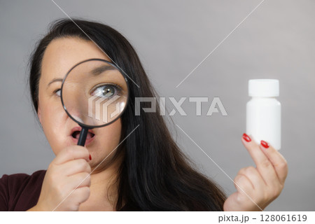 Woman investigating ingredients of medicines 128061619