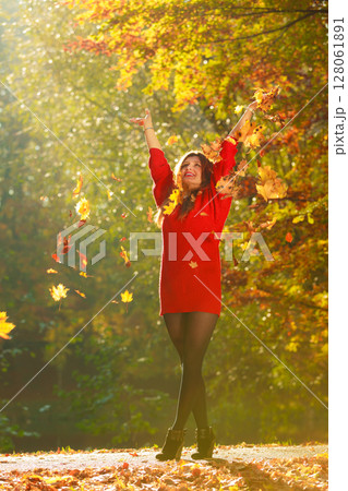 Joyful girl having fun with leaves in autumnal park. 128061891