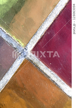 Close up abstract square stained glass window sections multicoloured background 128063094