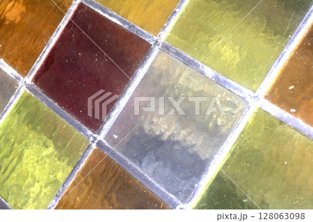 Close up abstract square stained glass window sections multicoloured background Close up abstract square stained glass window sections multicoloured background 128063098