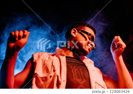 Stylish Man Dressed In Net Dancing In Neon Light, Smoke Studio Or In Night Club 128063426