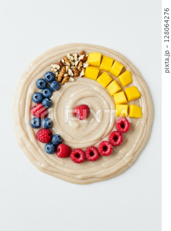 Creamy Smoothie Bowl with Berries, Mango, and Nuts 128064276