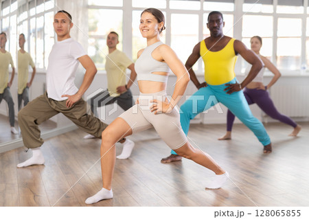 Young girl with group stretching before dance class in studio 128065855