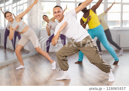 European guy with team of like-minded multinational people learn to elements of hip hop dance 128065857