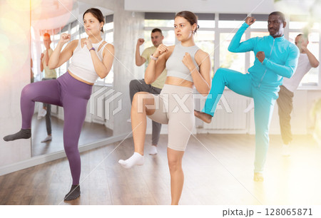 Girl practices kicking and punching in process of self-defense at group lesson 128065871