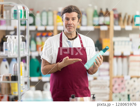 Adult male seller offering cleaning spray Adult male seller offering cleaning spray 128065976