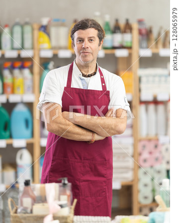 Man seller in apron invite and working in households store 128065979