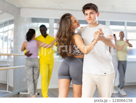 Young man and woman practicing waltz dance in pair in training hall 128066156