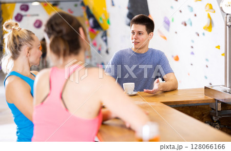 Young man talking with women in climbing center during break Young man talking with women in climbing center during break 128066166