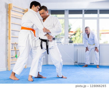 Adult and young men training judo fight Adult and young men training judo fight 128066265