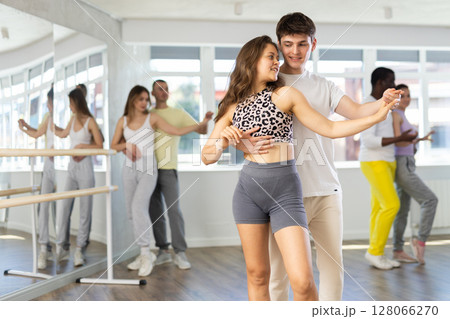 Ordinary adults dancing bachata together in dance studio Ordinary adults dancing bachata together in dance studio 128066270