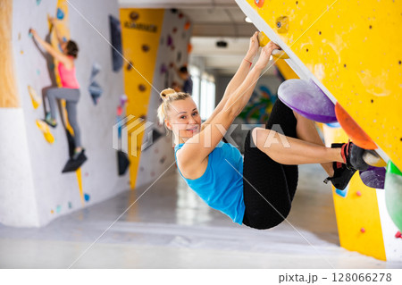Woman exercising in climbing gym Woman exercising in climbing gym 128066278