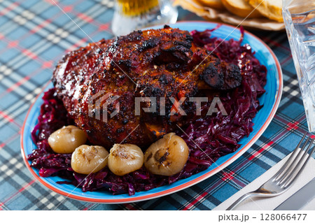 Baked knuckle with stewed red cabbage and baked onion Baked knuckle with stewed red cabbage and baked onion 128066477