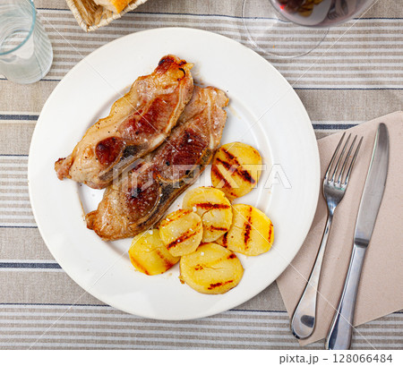Roasted pork chop with grilled potatoes garnish Roasted pork chop with grilled potatoes garnish 128066484