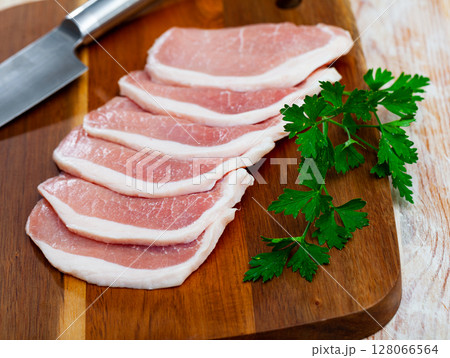 Preparation of raw pork loin on a wooden board Preparation of raw pork loin on a wooden board 128066564