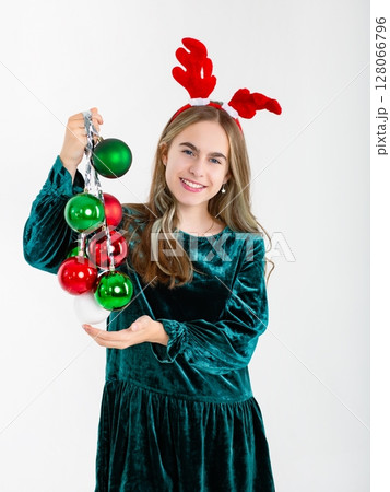Merry Christmas cute girl reindeer antlers holding Christmas decorations isolated white background Merry Christmas cute girl reindeer antlers holding Christmas decorations isolated white background 128066796