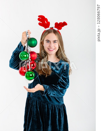 Merry Christmas cute girl reindeer antlers holding Christmas decorations isolated white background Merry Christmas cute girl reindeer antlers holding Christmas decorations isolated white background 128066797