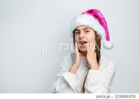 Girl Santa hat showing joy, delight, surprise, approval. Happy emotions, joy Christmas concept. Girl Santa hat showing joy, delight, surprise, approval. Happy emotions, joy Christmas concept. 128066858