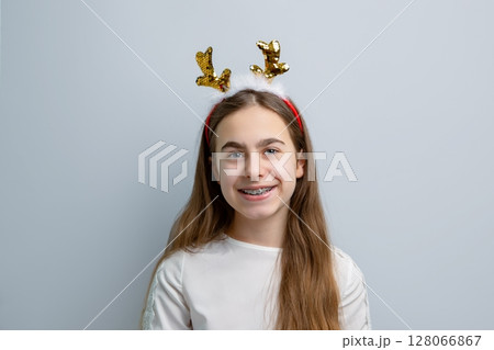 Cheerful girl reindeer antlers gray background showing different funny emotions, surprise, joy 128066867