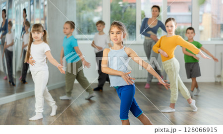 Girl learn to dance hip hop dances, doing movement with unrecognizable teacher. Girl learn to dance hip hop dances, doing movement with unrecognizable teacher. 128066915