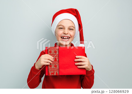 Boy Santa hat holding envelope, postcard, greeting, letter Santa different funny emotions, surprise 128066929