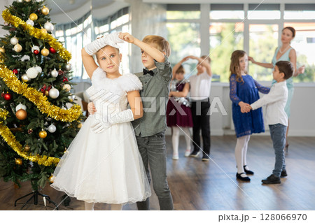 Viennese waltz performed by beautifully dressed children near Christmas tree Viennese waltz performed by beautifully dressed children near Christmas tree 128066970