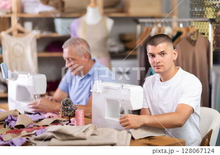 Two male workers in the atelier sewing Two male workers in the atelier sewing 128067124