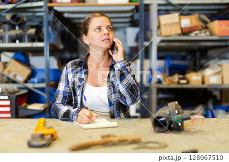 Portrait of young saleswoman confirming order from customer Portrait of young saleswoman confirming order from customer 128067510