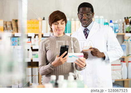 Woman buyer scans pills qr code with man pharmacist 128067525