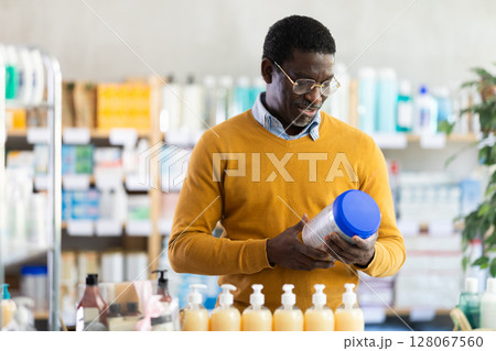 African American man choosing infant formula in pharmacy African American man choosing infant formula in pharmacy 128067560